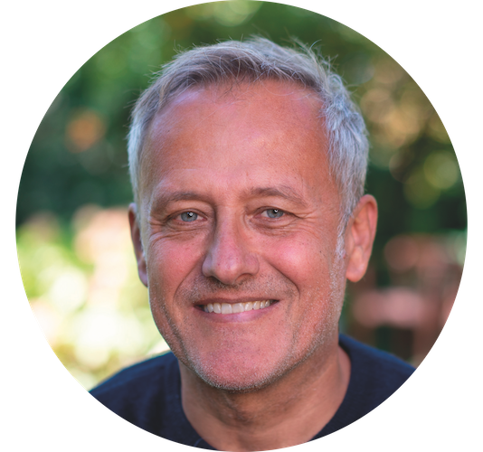 Portrait eines lächelnden Mannes in einem Garten